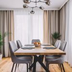 Dining room with wooden table and floor in modern apartment.